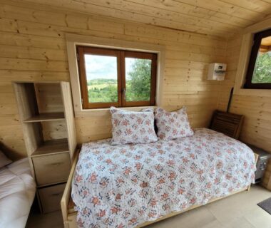 Intérieur de roulotte avec banquette et fenêtres sur la campagne Roulotte à Sapharey