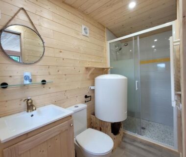 Salle de bains en bois avec douche et WC de la Roulotte à Sapharey