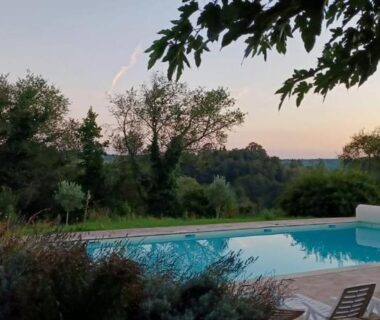 Piscine extérieure entourée d'arbres au camping Roulotte à Sapharey