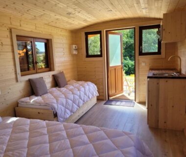 Intérieur en bois avec lits et kitchenette dans la Roulotte à Sapharey