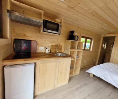 Intérieur avec kitchenette et lit dans la Roulotte à Sapharey