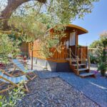 Terrasse en bois avec chaises longues devant la roulotte au cœur des vignes Hyères