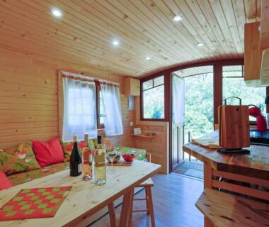 Intérieur en bois avec table dressée et bouteilles de vin dans la Roulotte au cœur des vignes