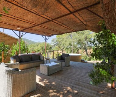 Terrasse en bois ombragée avec salon extérieur dans la Roulotte au cœur des vignes à Hyères