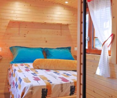 Intérieur avec lit en bois et fenêtre dans la Roulotte au cœur des vignes, Hyères