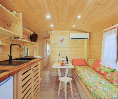 Intérieur en bois avec kitchenette et banquette dans la Roulotte au cœur des vignes Hyères