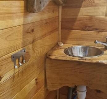 Intérieur lavabo en bois dans la Roulotte avec piscine la jonquille