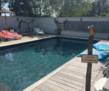Piscine et transats sur terrasse en bois à la Roulotte hébergement atypique