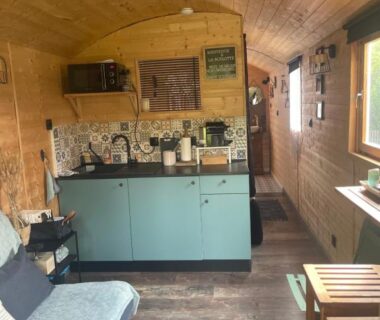 Intérieur de roulotte avec kitchenette canapé et coin repas dans la Roulotte
