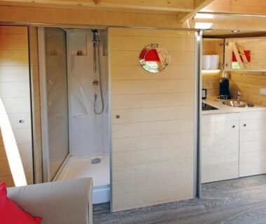 Intérieur de roulotte avec cabine de douche et kitchenette dans les Roulottes et Cabanes de Saint Cerice