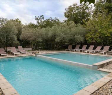 Piscine extérieure avec transats entourée d'arbres aux Roulottes et Cabanes de Saint Cerice