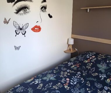Chambre avec lit et décor mural papillons au SABLE DU MIDI chez gégé