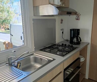Cuisine aménagée avec évier et plaque de cuisson dans le mobil-home SABLE DU MIDI chez gégé