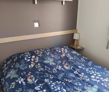Chambre avec lit et lampe de chevet au SABLE DU MIDI chez gégé