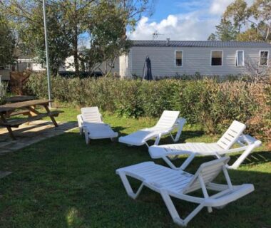 Pelouse avec transats et table devant le mobil home du SC L'Aventura 3 ch 2 SDB tout confort