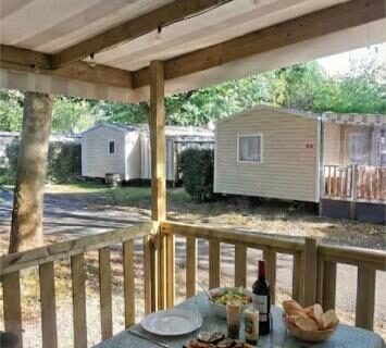 Terrasse couverte avec table dressée et vue sur mobil homes du SIBLU la Réserve 321 near lake 8 Per 2SDB