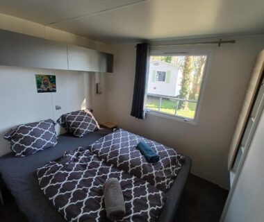 Chambre avec lits doubles et fenêtre donnant sur l'extérieur du Safari Mobilhome near EP mit AC