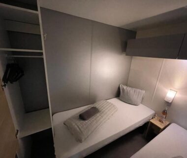 Intérieur chambre avec lit simple et placard dans le Safari Mobilhome near EP mit AC