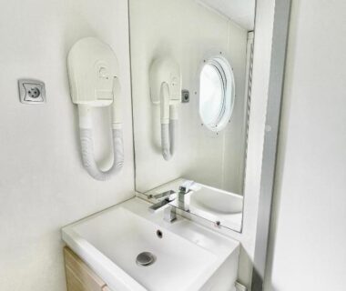 Salle de bain avec lavabo miroir et hublot dans le Safari Mobilhome near EP mit AC