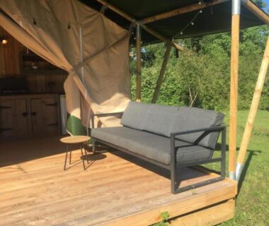 Terrasse en bois avec canapé et coin cuisine du SafariLodge 6 persoons