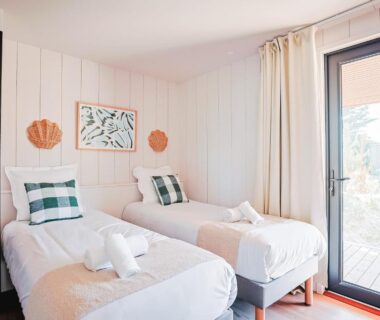 Chambre avec deux lits et porte-fenêtre au camping Sauvage