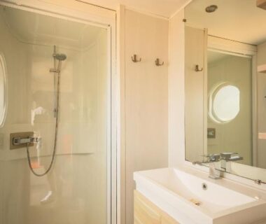 Salle de bain avec douche vitrée et vasque dans le camping Sauvage