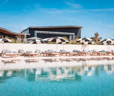 Piscine bordée de transats et parasols au camping Sauvage