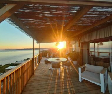Terrasse face à la mer au coucher de soleil avec mobilier en bois au Sea View Amazing