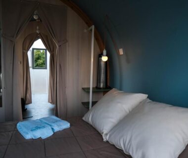 Intérieur de tente avec lit et ouverture sur verdure au Seasonova Camping Les 7 iles