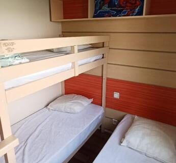 Chambre avec lits superposés et lit simple dans le mobilhome Séjour Normandie 5P