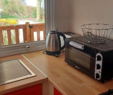 Cuisine avec bouilloire mini four et vue sur terrasse dans le mobilhome Séjour Normandie