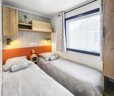 Chambre avec deux lits simples et fenêtre au Séjour en Forêt 4 étoiles