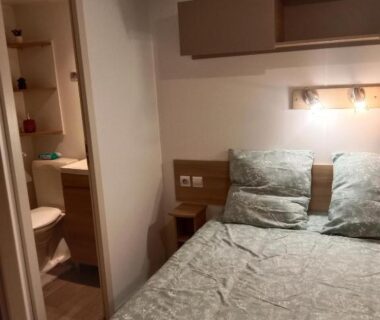 Chambre avec lit et serviettes dans le mobile home LUMINOSA
