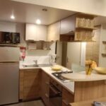 Cuisine équipée avec réfrigérateur micro-ondes et plaque de cuisson dans le mobile home LUMINOSA