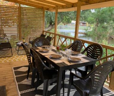 Terrasse couverte avec table à manger et vue sur le bassin du Siblu Village Les Viviers mobile home 3 chambres