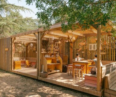 Terrasse couverte avec coin repas et mobilier en bois au Slow Village Anduze – Cévennes