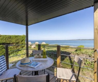 Terrasse couverte avec table et chaises face à la mer au Slow Village Breizh Légendes