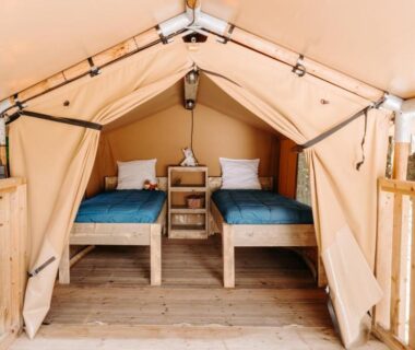 Intérieur de tente avec deux lits sur terrasse en bois au Slow Village Pornic