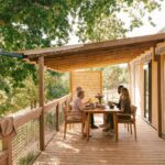 Terrasse en bois avec table et deux personnes au Slow Village Pornic