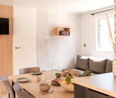 Séjour avec table dressée et canapé dans un locatif du Slow Village Pornic