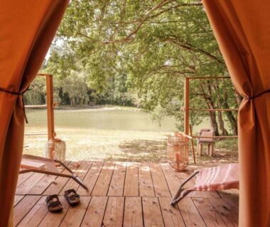 Terrasse en bois avec chaises longues donnant sur l'étang au Slow Village Séveilles – Périgord