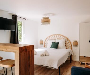 Chambre avec lit double et télévision dans le Slow Village Séveilles Périgord