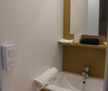 Lavabo avec miroir et serviette roulée dans le Studiotel premium 2 personnes