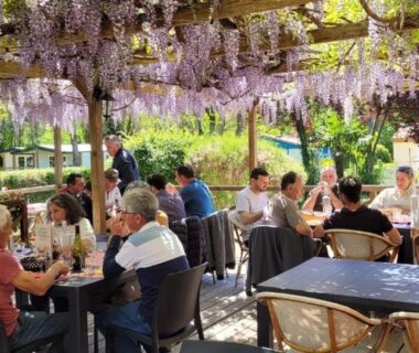 Terrasse ombragée sous pergola fleurie avec convives au Studiotel premium 2 personnes
