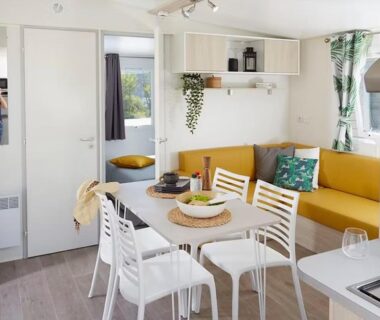 Intérieur mobil-home avec coin repas et kitchenette au Sun Sea camping le Bosc