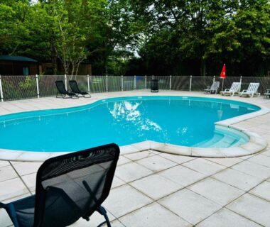 Piscine extérieure bordée de transats au Superbe Mobilehome 3 ch climatisé tout confort