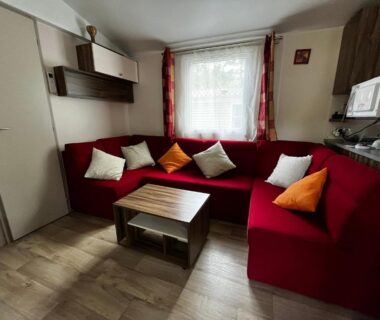 Séjour avec canapé rouge et table basse dans le Superbe Mobilehome 3 ch, climatisé tout confort