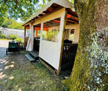 Terrasse ombragée sous un chêne avec coin repas et fauteuils du Superbe Mobilehome 3 ch climatisé tout confort