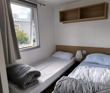 Chambre avec deux lits et fenêtre dans le Superbe mobil home 8 pers tout confort camping 4 étoiles