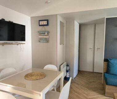 Séjour avec table à manger canapé et télévision dans le Superbe mobil home 8 pers tout confort camping 4 étoiles
